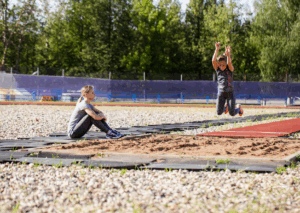Verspringen in een verspringbak van de atletiekbaan