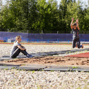 Verspringen in een verspringbak van de atletiekbaan