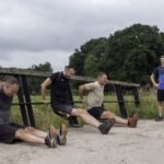 Groep mensen die een bootcamp oefening doen onder leiding van een instructeur
