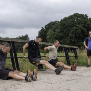 Groep mensen die een bootcamp oefening doen onder leiding van een instructeur