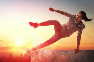 Jonge sportieve vrouw buiten is bezig met freerunning