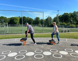 Volwassen mensen doen beweegactiviteiten op een meer sportplein in Kloosterhaar