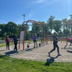 Volwassen mensen doen beweegactiviteiten op een meer sportplein in Kloosterhaar
