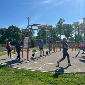 Volwassen mensen doen beweegactiviteiten op een meer sportplein in Kloosterhaar