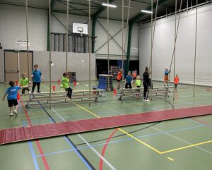 Meerdere kinderen die aan touwen zwaaien in een gymzaal