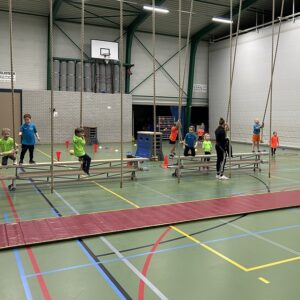 Meerdere kinderen die aan touwen zwaaien in een gymzaal