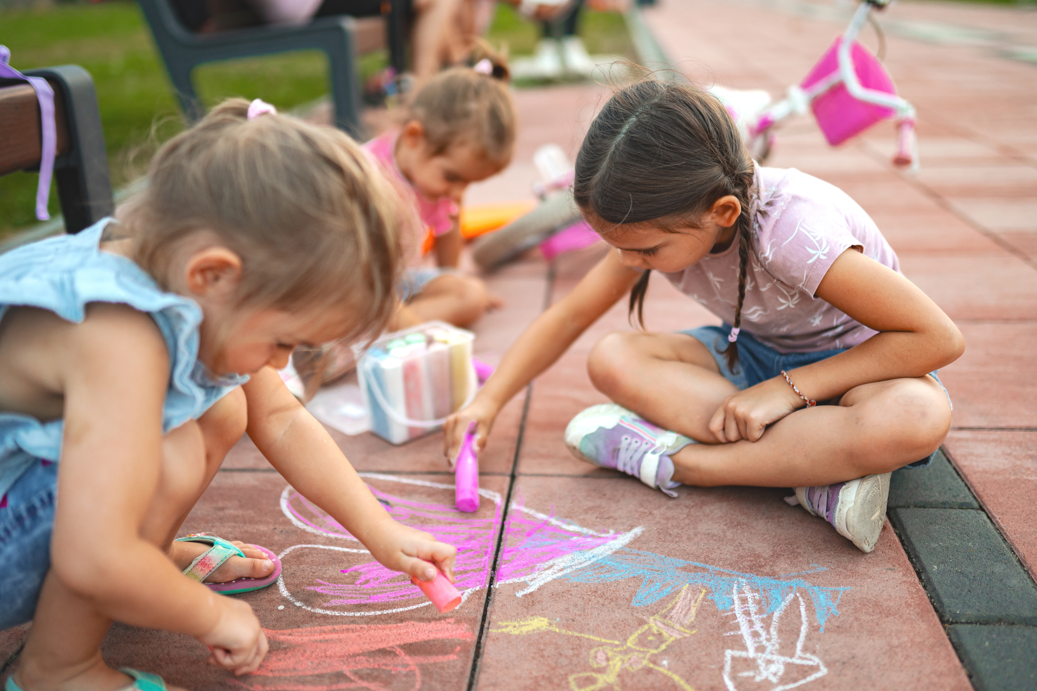 Jonge kinderen spelen met stoepkrijt