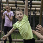 Meerdere kinderen leggen een survivalparcours af op een survivalbaan