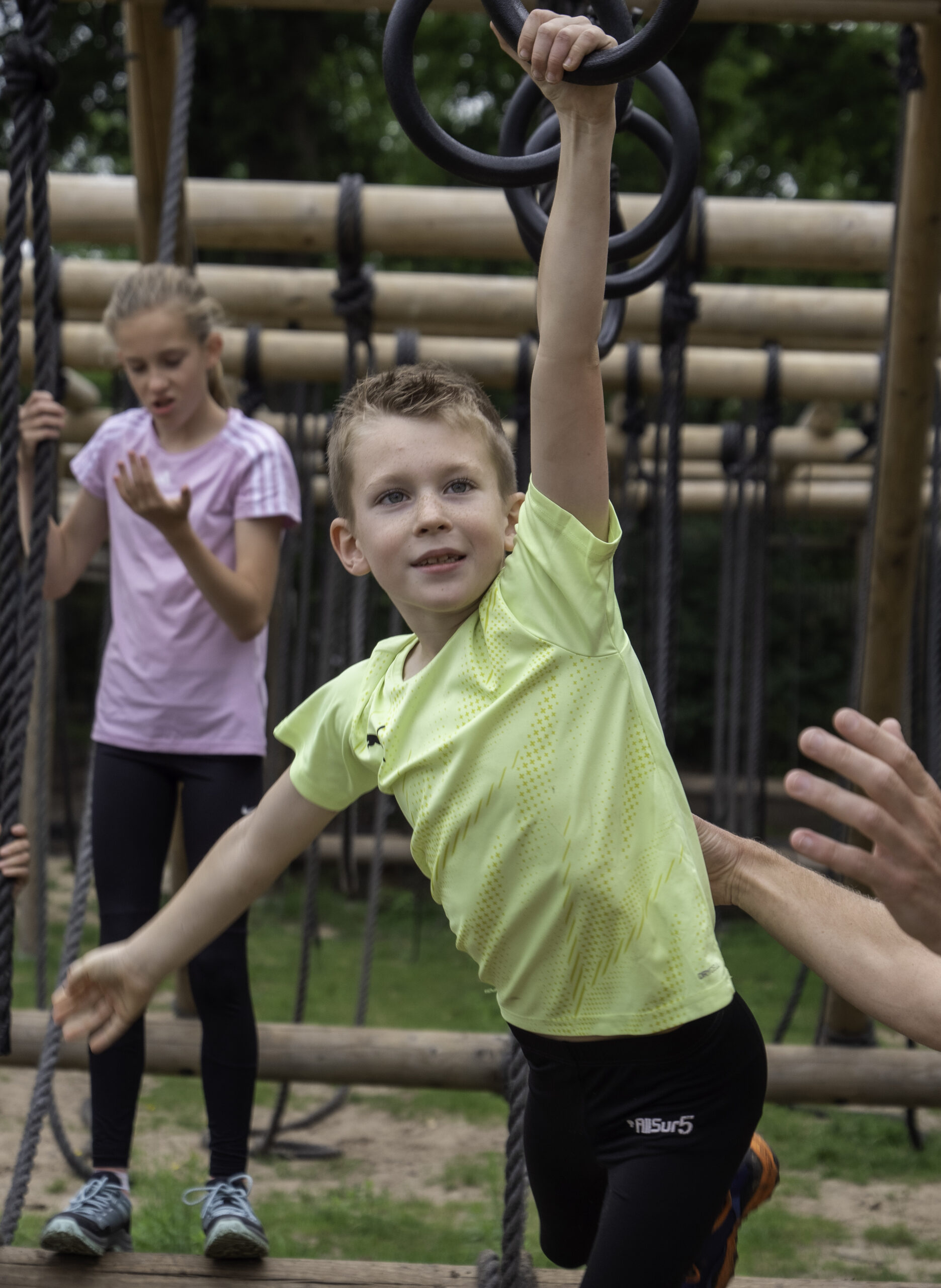 Meerdere kinderen leggen een survivalparcours af op een survivalbaan