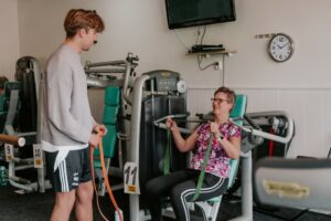 2 sporters, man en vrouw, bezig in sportschool