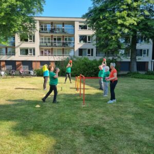 Mannen en vrouwen die samen buiten bewegen op een grasveld
