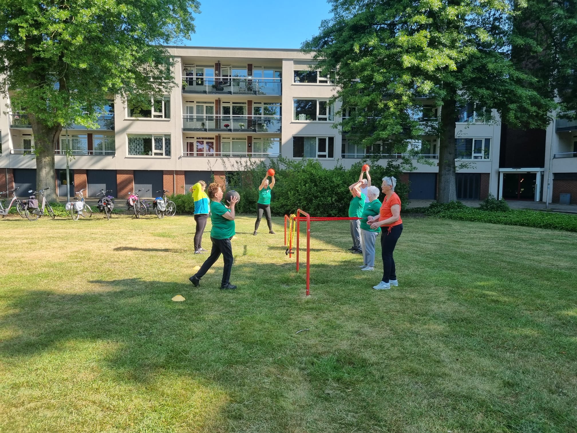 Mannen en vrouwen die samen buiten bewegen op een grasveld