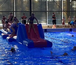 Kinderen op een stormbaan in het zwembad