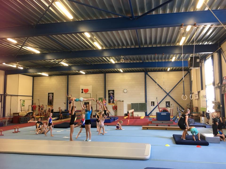 Turnsters die verschillende oefeningen uitvoeren in de turnhal