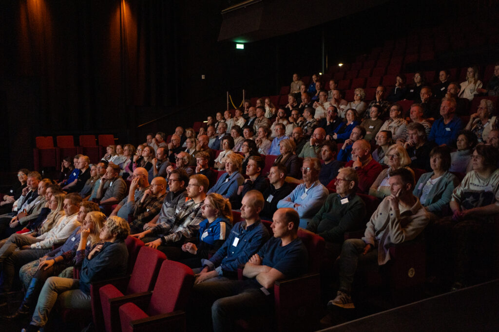 Publiek van mannen en vrouwen die zitten in een theaterzaal