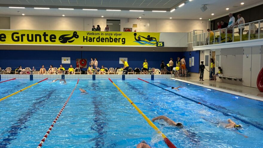 Meerdere zwemmers zijn aan het banenzwemmen in een binnenbad
